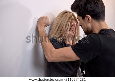 male attacks woman, domestic violence. Drunk husband beats wife. An aggressive man hits young wife, female, crying. Pinned to the wall and scared. family domestic domination couple Royalty-Free Stock Photo #2110374281