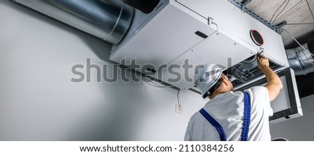 hvac engineer install heat recovery ventilation system for new house. copy space Royalty-Free Stock Photo #2110384256