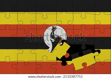 World countries. Broken puzzle- background in colors of national flag. Uganda