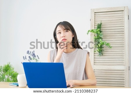 Asian woman using the laptop
 at home Royalty-Free Stock Photo #2110388237