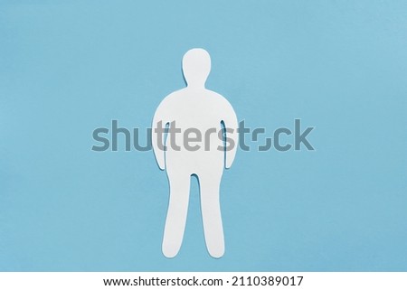 Paper silhouette of a fat man on a blue background. Flat lay, place for text. Concept of body positive.