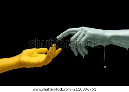 Moment of weightless. Two painted hands trying to touch each other isolated on dark studio background in neon light. Concept of human relation, community, togetherness, symbolism, culture and history