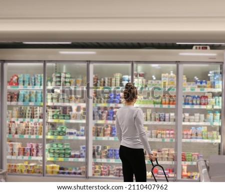 Woman choosing frozen food from a supermarket freezer	 Royalty-Free Stock Photo #2110407962