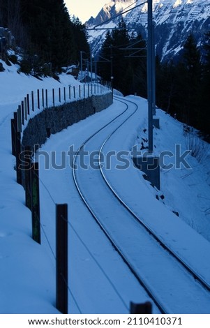 Winding railroad tracks in the Swiss Alps between mountain village Mürren and Winteregg on a sunny winter day. Photo taken January 15th, 2021, Lauterbrunnen, Switzerland.
