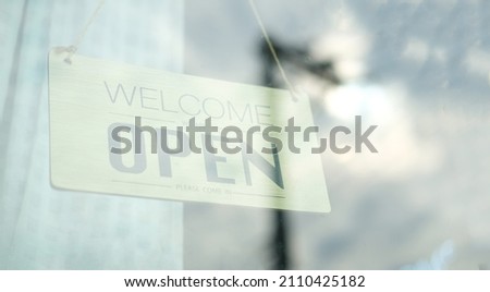 Wooden open sign board hanging on door at cafe or restaurant.