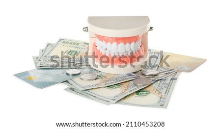 Educational dental typodont model, money and credit cards on white background. Expensive treatment