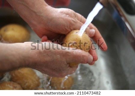 Person washing potatoes with water