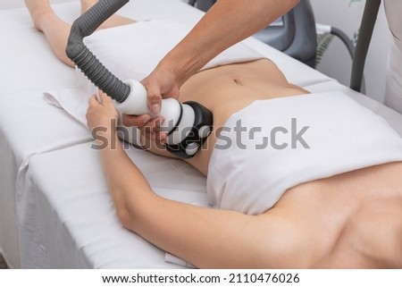 young woman in an aesthetic center performing a treatment for the beauty of the skin and body with the method of velaslim plus applied by an aesthetic professional Royalty-Free Stock Photo #2110476026