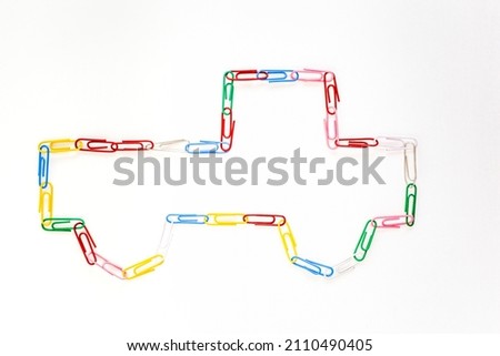 Figure of a truck made of colored school paper clips on a white background Royalty-Free Stock Photo #2110490405