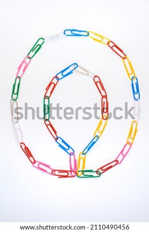 Figure number zero from colored school paper clips on a white background Royalty-Free Stock Photo #2110490456