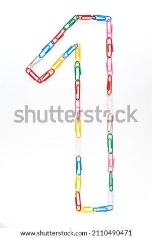 Figure number one from colored school paper clips on a white background Royalty-Free Stock Photo #2110490471