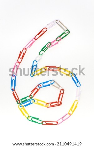 Figure number six from colored school paper clips on a white background Royalty-Free Stock Photo #2110491419