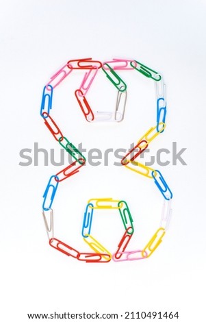Figure number eight from colored school paper clips on a white background Royalty-Free Stock Photo #2110491464
