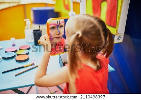 Children face painting. Artist painting little preschooler girl like butterfly. Creative activities for kids Royalty-Free Stock Photo #2110498397
