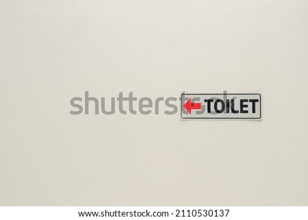 Toilet sign is posting on the white wall