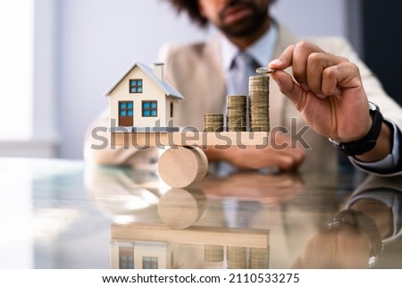 House Model Balance Equilibrium Concept. Real Estate Money Royalty-Free Stock Photo #2110533275