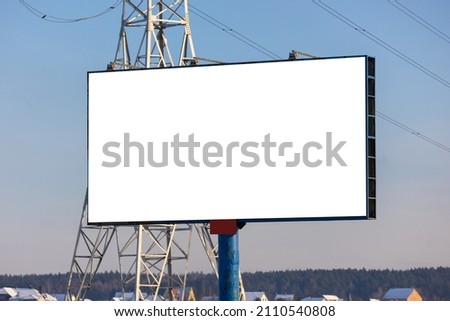 white billboard along the highway on a winter snow day. Background for design and advertising. 