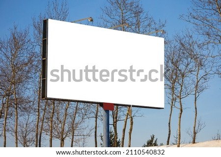 white billboard along the highway on a winter snow day. Background for design and advertising. 