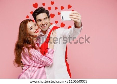 Young couple two friends woman man 20s in casual shirt doing selfie shot on mobile cell phone isolated on plain pastel pink background studio portrait. Valentine's Day birthday holiday party concept