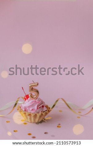 a beautiful picture of a cupcake with pink butter cream and cherry with a number five 5 candle on the top of it. Festive Happy birthday mood. Card design idea