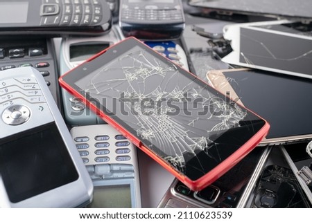 A heap of old used smartphones and mobile phones with keyboards, Many types and generations of mobile smartphone gadgets, top view, selective focus, close up Royalty-Free Stock Photo #2110623539