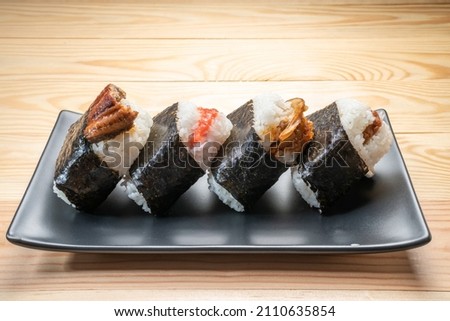 Onigiri or Japanese seaweed rice triangles shaped Stuffed with grilled eel, scallop, plum and fish roe, Japanese Rice Balls  famous food. Royalty-Free Stock Photo #2110635854