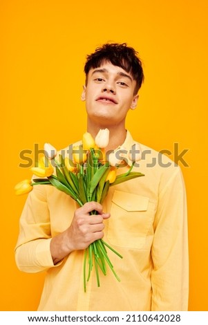 handsome guy in yellow glasses with a bouquet of flowers isolated background unaltered