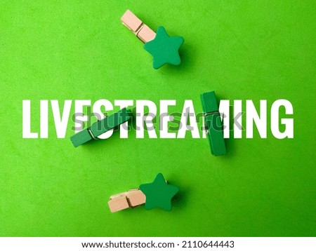 Colored wooden clips with text LIVESTREAMING on green background.