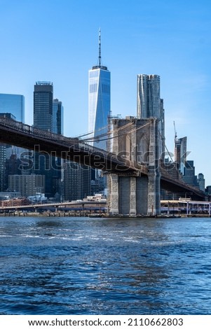 Brooklyn bridge and Manhattan financial center view from Dumbo park   Brooklyn. Sunny winter day. Portrait image with One World Trade Center in the center. 
