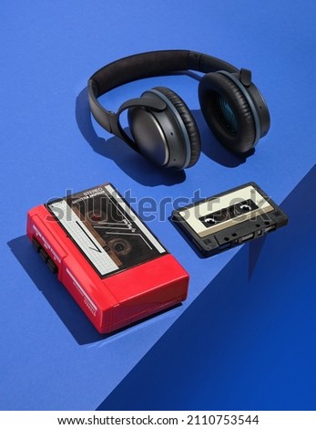 Retro composition with cassette player, audio cassette and headphones. Aesthetics of music, 80s and minimalist style. Royalty-Free Stock Photo #2110753544