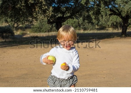 Portrait Of A Funny Baby.
Stock Photo Of A Beautiful Blond Little Boy Running Through The Park, He Is Smiling