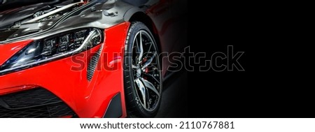 Front headlights of red modify car on black background, copy space	 Royalty-Free Stock Photo #2110767881