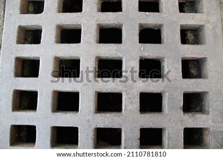 close-up photo of a sewer cover made of iron