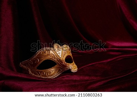 Luxury venetian mask on dark red background. Carnival masquerade fantasy mask Royalty-Free Stock Photo #2110803263