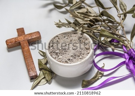 Bowl with ashes, olive branch and cross, symbols of Ash Wednesday Royalty-Free Stock Photo #2110818962