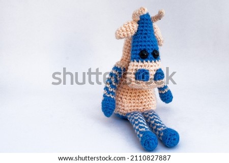 Amigurumi doll handmade goby sits, background isolate.