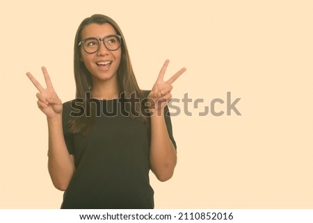Portrait of young beautiful woman shot against studio background