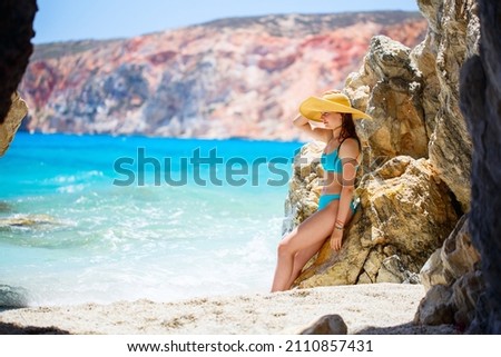 Cute teen girl enjoying breathtaking beach dotted with amazing sea caves on Greek island of Milos