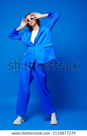 Fashion asian female model in blue suit, white boots and sunglasses. Asian fashion Royalty-Free Stock Photo #2110877279
