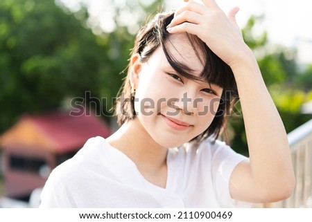 Portrait of young adult asian business woman looking camera. At outdoor under sunlight background with copy space.