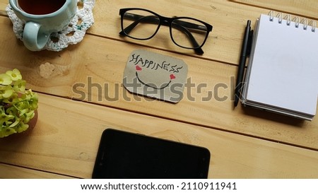 Happiness text on a note on rustic wooden table. Selective focus.
