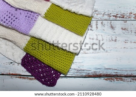 
Crocheted, knitting plaid in patchwork style. Knitted squares with a different pattern of green, white, lavender, pink. Female hands fold a plaid.