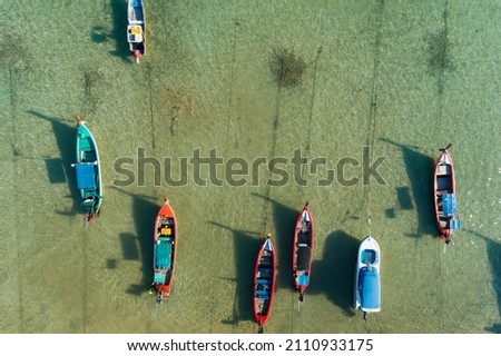 Aerial drone bird's eye view photo Top down of tropical sea with long tail fishing boats Travel boats at phuket thailand Amazing top view sea Beautiful sea surface