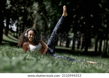 Beautiful african american latina girl doing physical exercises in the summer in the park. T