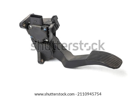 Floor gas pedal on a white isolated background in a photo studio for sale in a car service. Black auto part for replacement during repair in the workshop. Spare part junkyard.