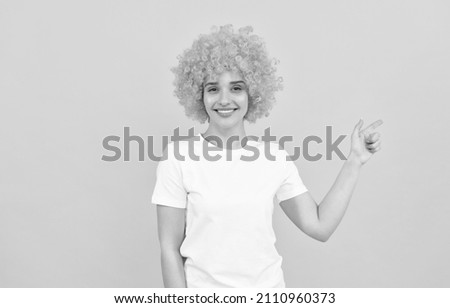 happy freaky woman in curly clown wig pointing finger, gesture and emotions