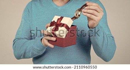 wristwatch in present box in hand of cropped man, mens day Royalty-Free Stock Photo #2110960550