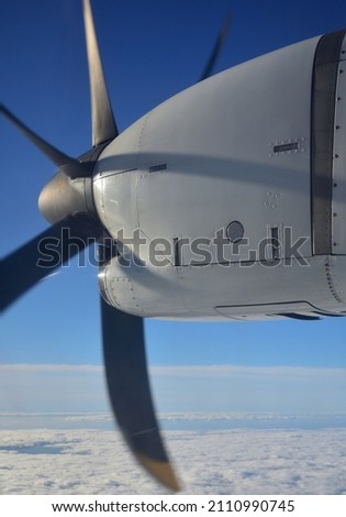 Turboprop engine in mid-flight with blue sky and clouds in the background