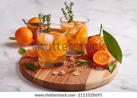 Ice tea with orange juice, ice cubes, and thymes. Refreshing cold spring and summer citrus beverage.  Royalty-Free Stock Photo #2111028695