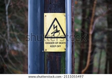 High voltage yellow danger sign in forest